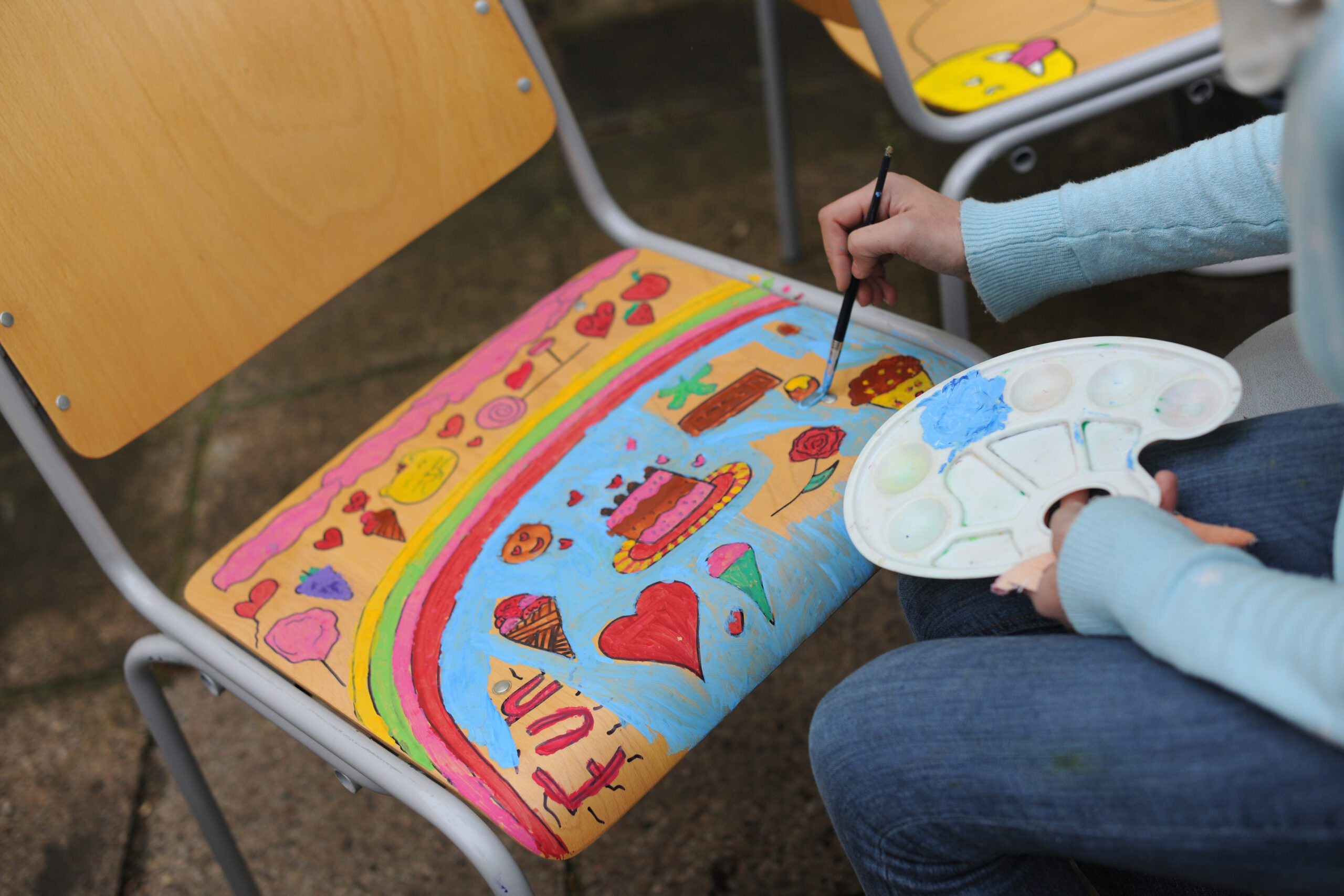 Kind bemalt Schulstuhl bunt
