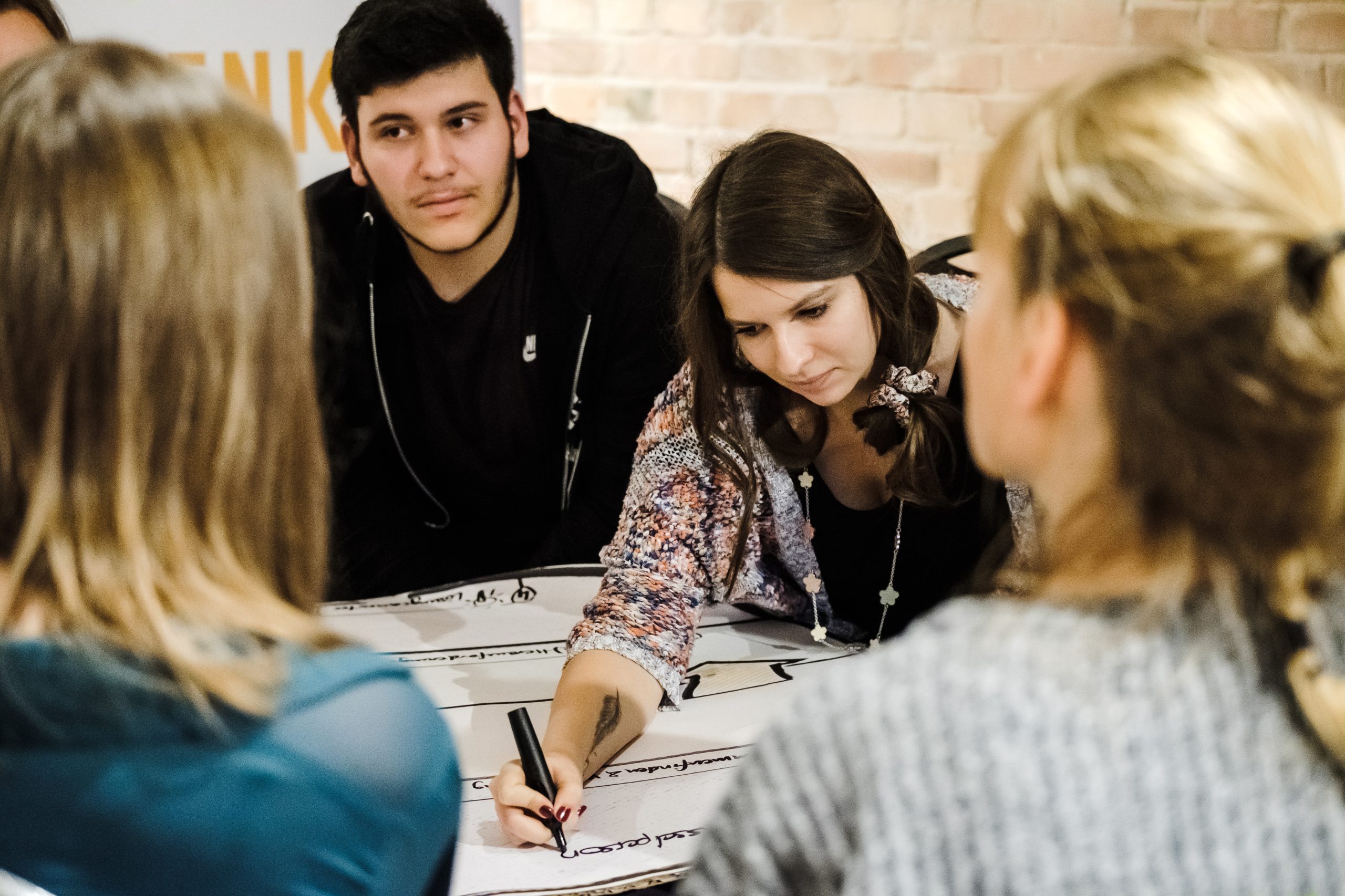 Das Bild zeigt eine Gruppe junger Menschen, die an etwas arbeiten.